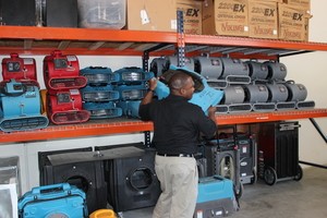 Water Damage Restoration Technician Mobilizing Air Movers